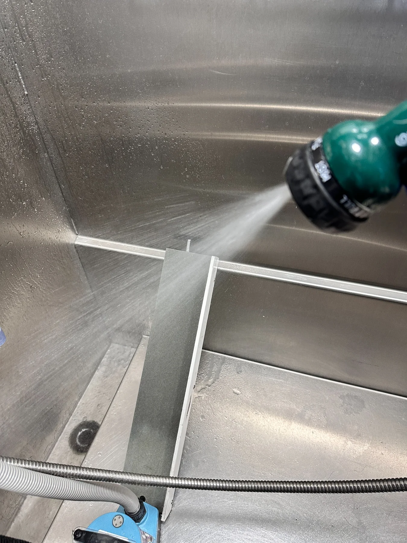 Cleaning a stainless tub inside a mobile pet styling van